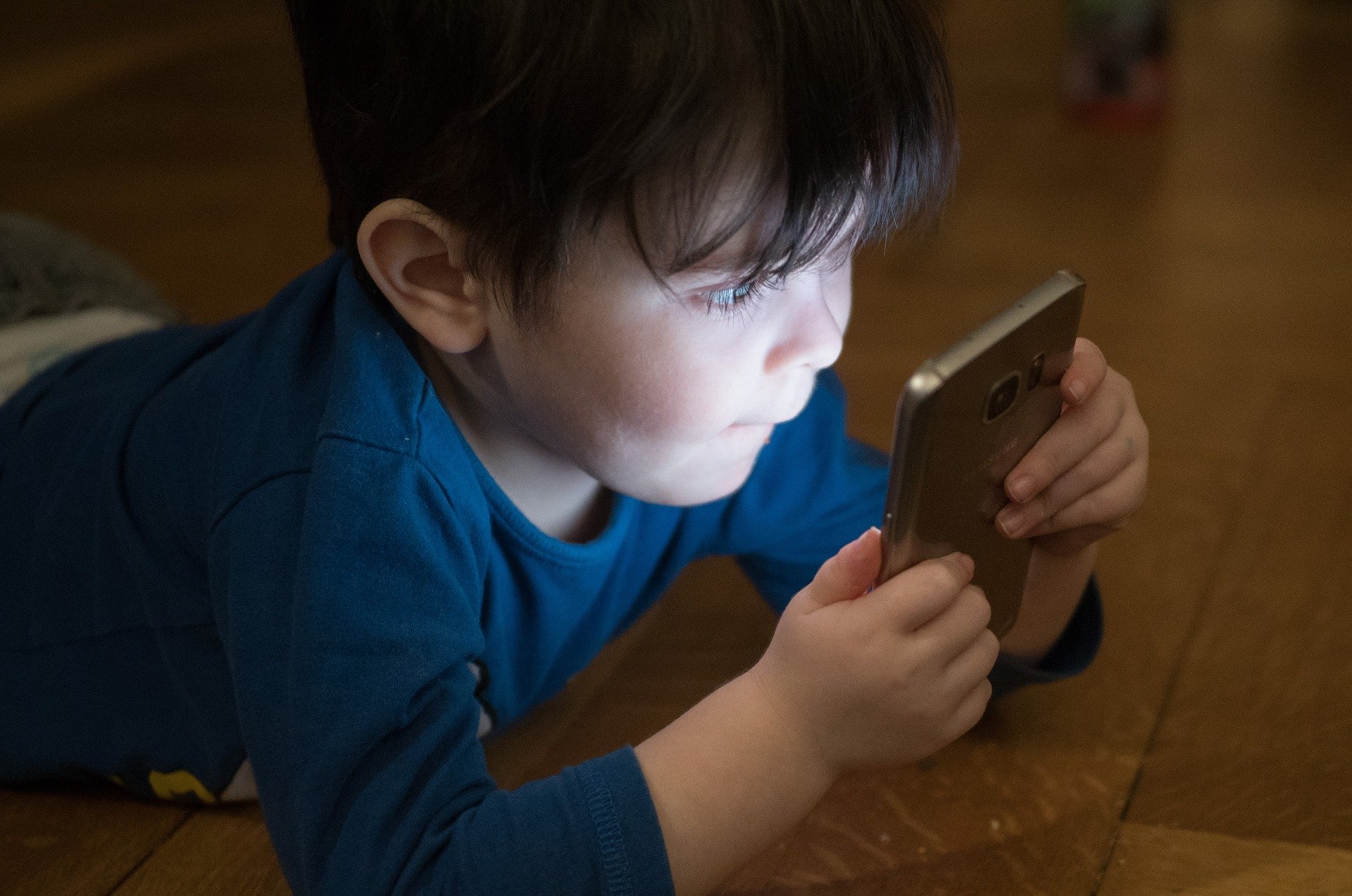 Niño con un teléfono entre las manos que podría desarrollar una adicción de adulto